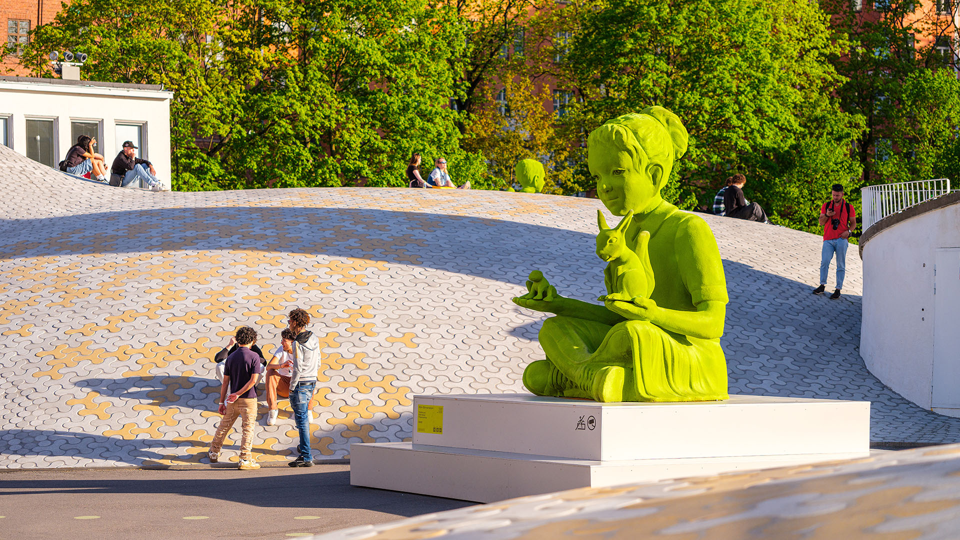 Valtava sammaltyttö istuu Lasipalatsinaukiolla orava sylissään.