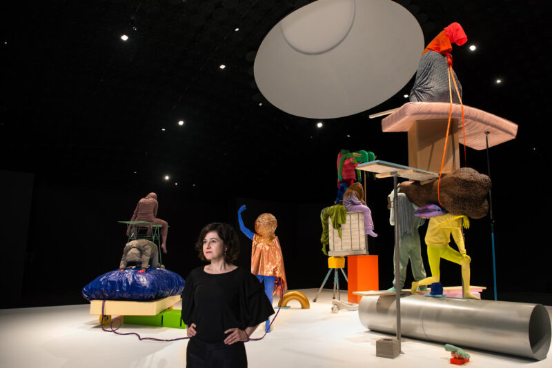 Anna Estarriola standing in front of her artwork.