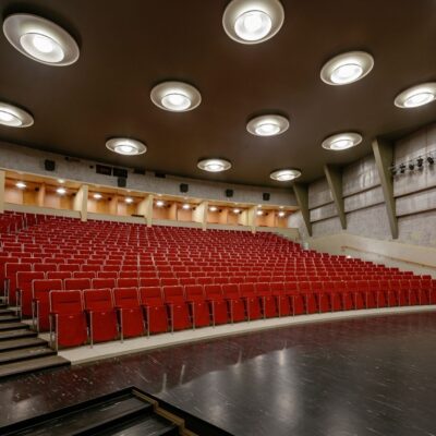 A movie theater auditorium. The seats are red.