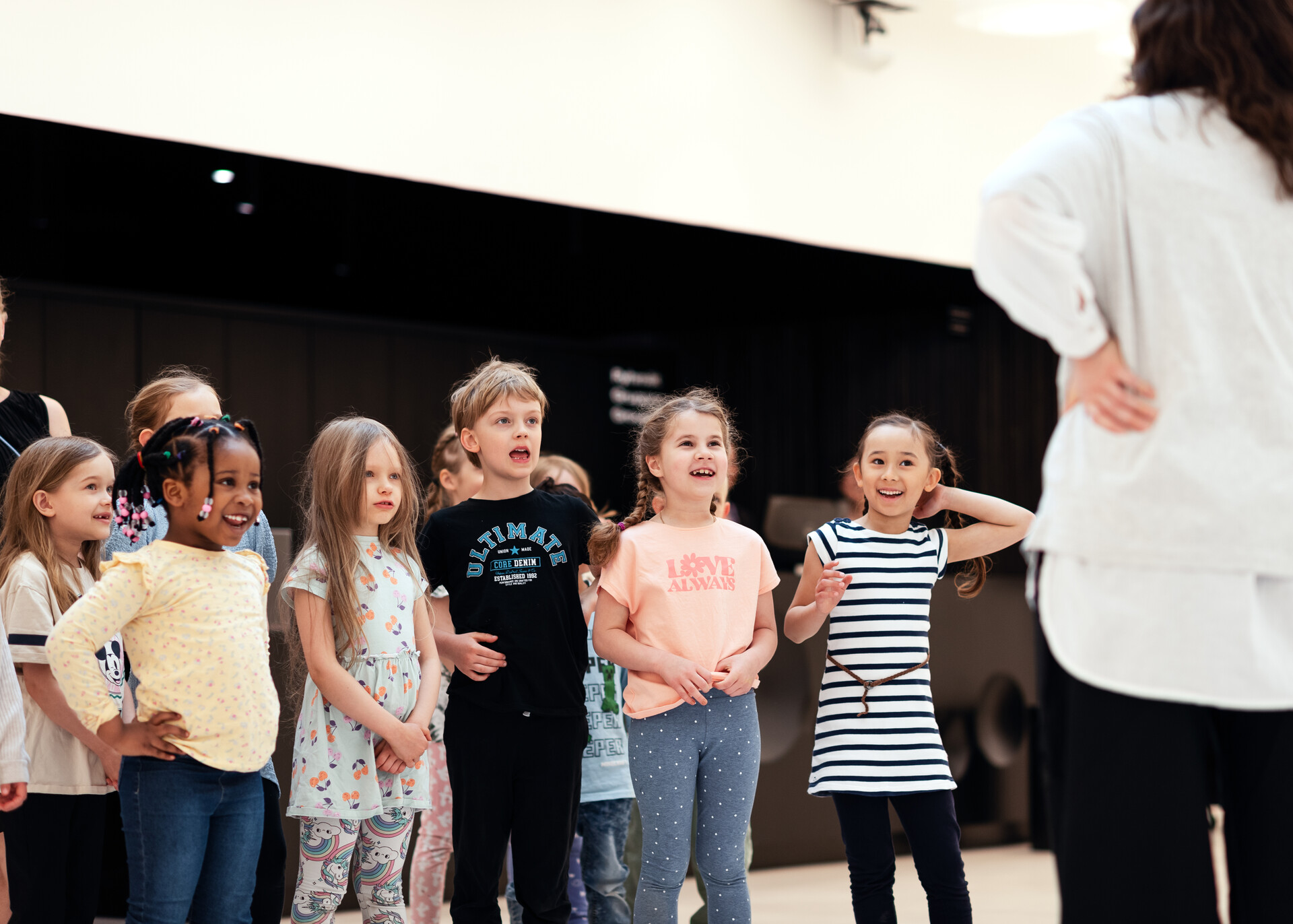 Joukko lapsia juttelee innoissaan Amos Rexin museolehtorin kanssa.