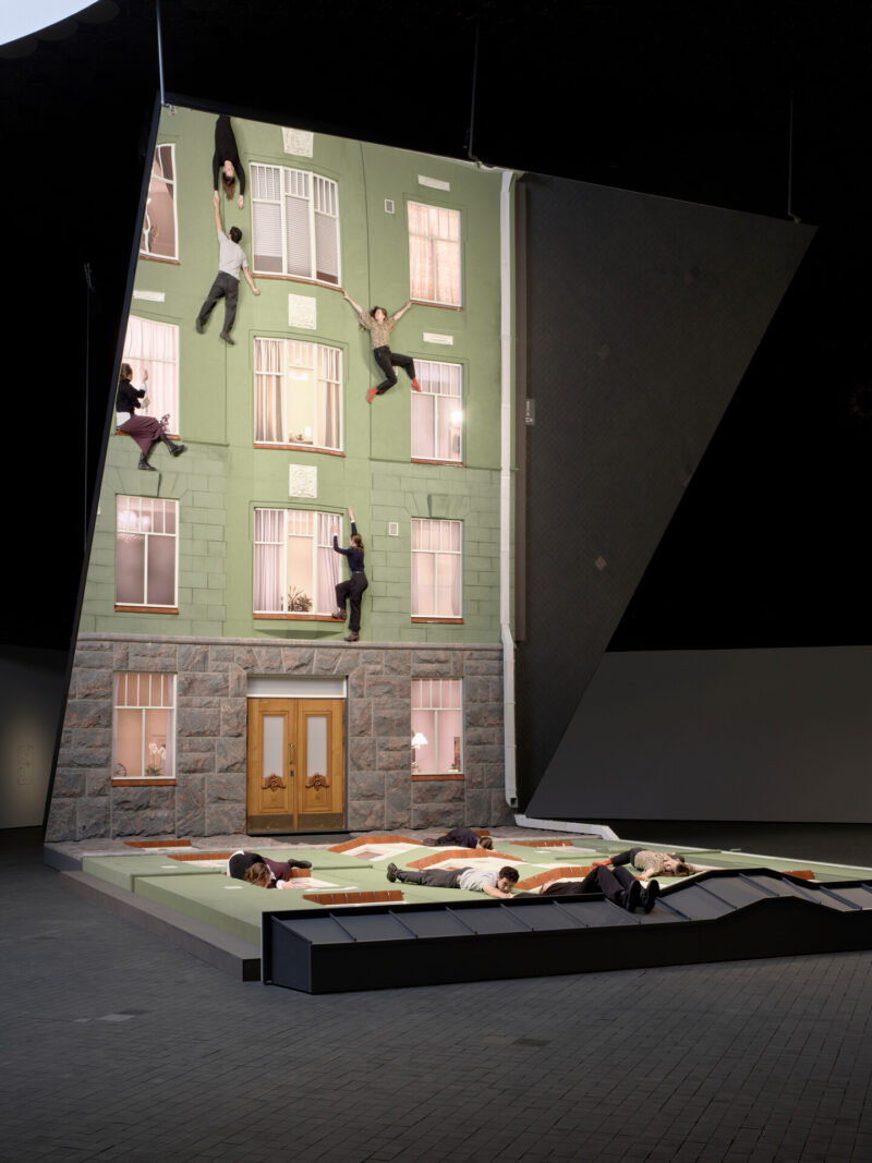 The façade of a building reflected in a large mirror.