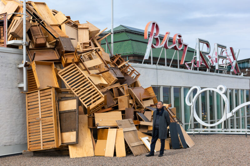 Artist Tadashi Kawamata posing for the camera in front of the Nest.