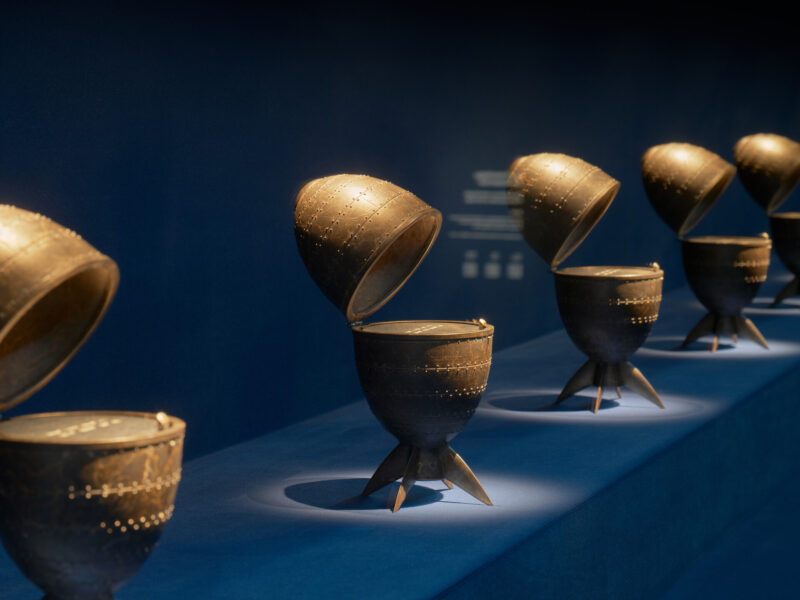 A row of bronze sculptures shaped like eggs split open along the middle.