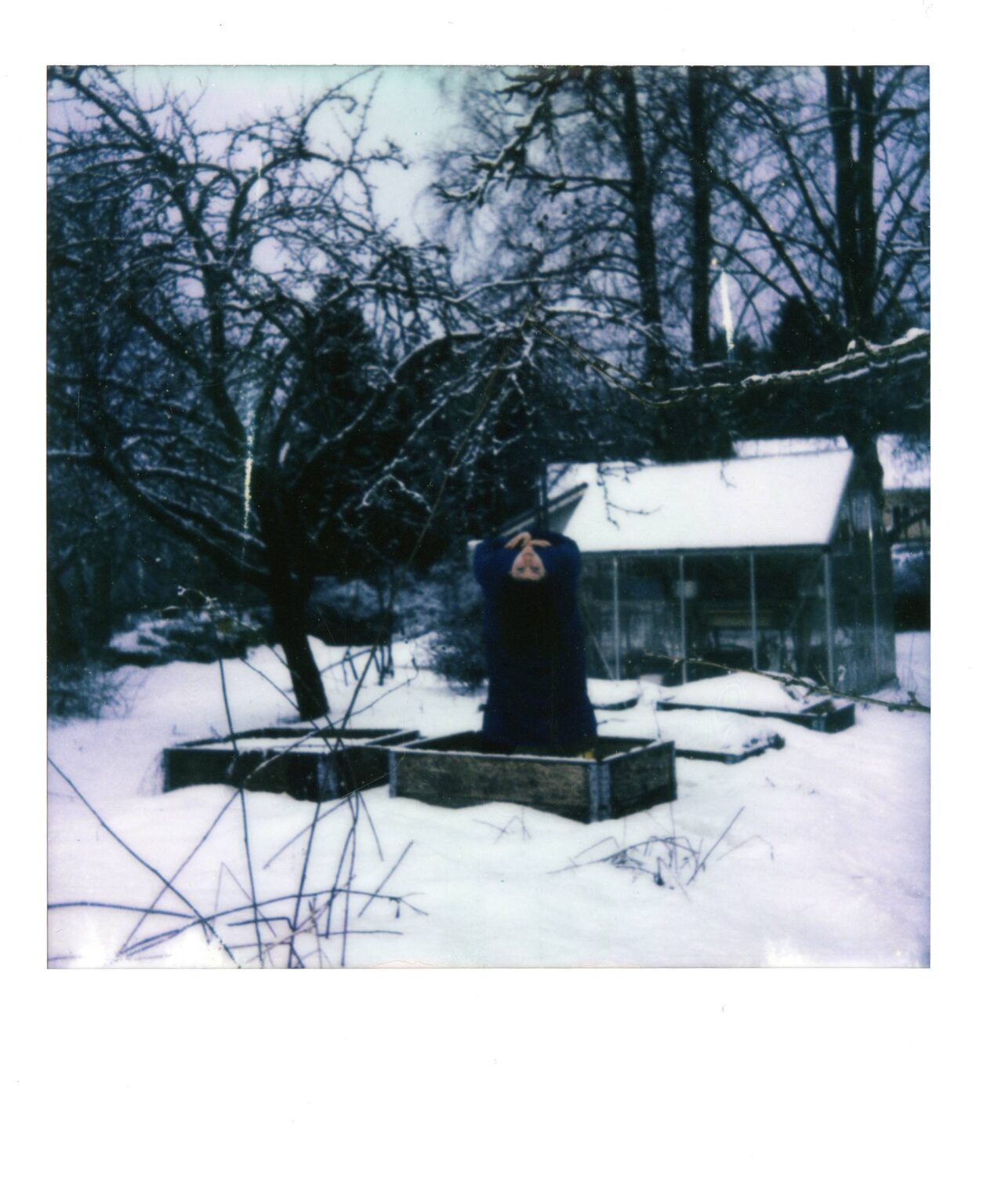 A person dressed in black in a snowy yard.